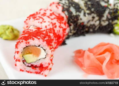 Sushi rolls made of fish avocado and different flying fish roe (tobiko caviar)