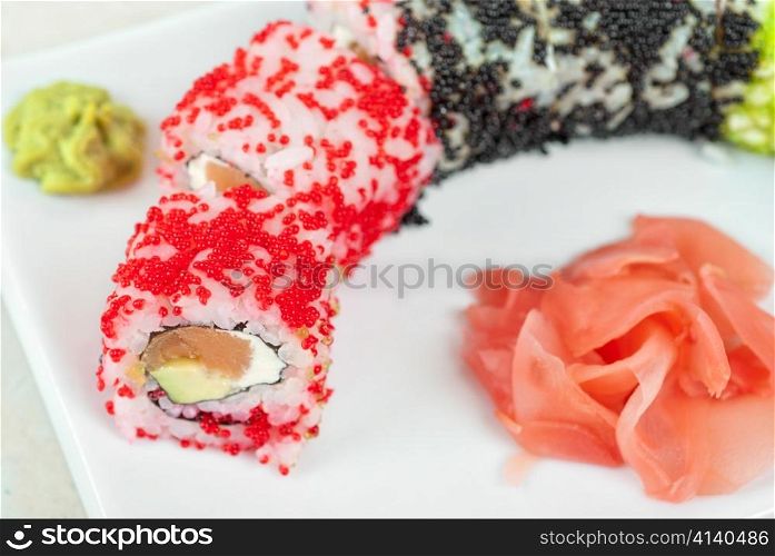 Sushi rolls made of salmon, avocado, flying fish roe (tobiko caviar) and philadelphia cheese
