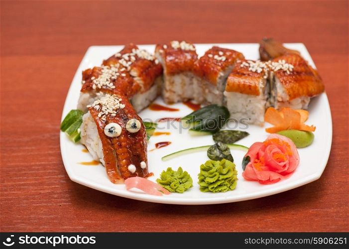 Sushi rolls. Roll dragon made of smoked eel at plate
