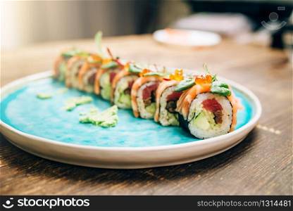 Sushi rolls with salmon fish on plate closeup. Traditional oriental food, japanese kitchen, asian cuisine. Sushi rolls with salmon fish on plate closeup