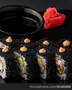 Sushi rolls with tuna and caviar on black plate
