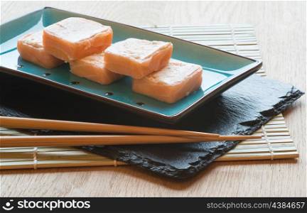 Sushi salmon parcels on dish with chopsticks