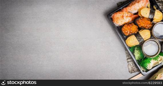 Sushi set in transport box on gray stone background, top view, place for text, banner
