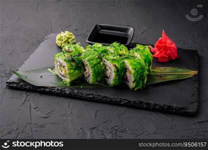 Sushi set uramaki decorated with wasabi and seaweed salad