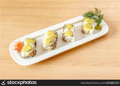 Sushi uramaki california roll with sesame and poppy seeds, yellow cream, salmon and wasabi with fresh dill