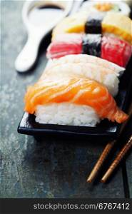 sushi with chopsticks on old wooden background