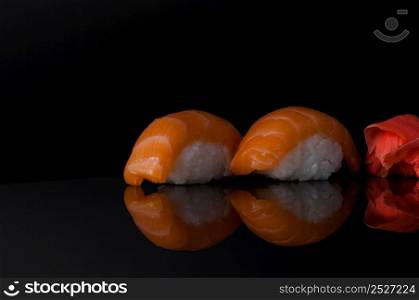 sushi with rice and wasabi on a dark background with reflection. sushi on black background