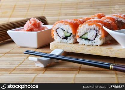 sushi with salmon and avocado on wooden background