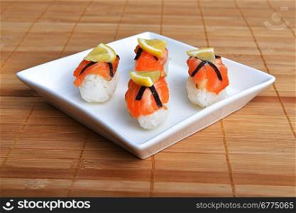 sushi with salmon and lemon on bamboo napkin