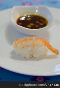 sushi with tiger shrimp on white plate served with sauce
