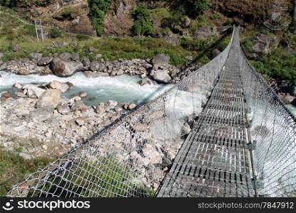 Suspension bridge and river in mountain Nepal