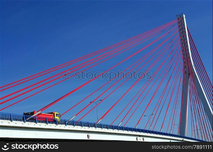 Suspension bridge over the Martwa Wisla in Gdansk, Poland with truck and blue sky.
