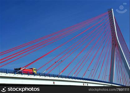 Suspension bridge over the Martwa Wisla in Gdansk, Poland with truck and blue sky.