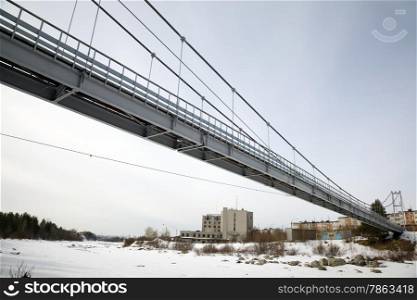Suspension Bridge over the River Niva. Winter landscape.