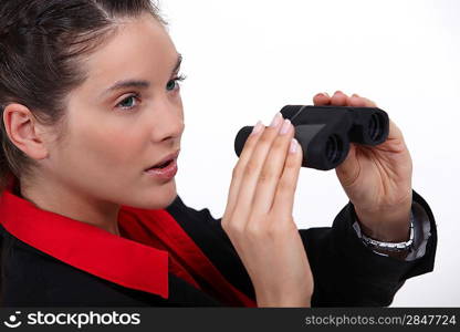 Suspicious woman watching through binoculars