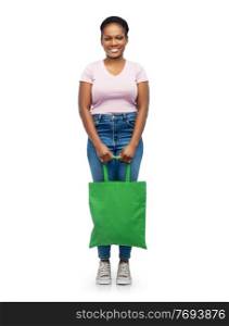sustainability and people concept - happy smiling young african american woman with green reusable canvas bag for food shopping over white background. woman with reusable canvas bag for food shopping
