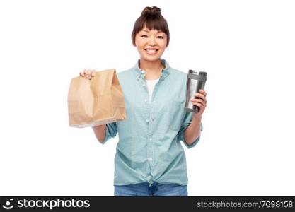 sustainability and people concept - portrait of happy smiling young asian woman in turquoise shirt with thermo cup or tumbler for hot drinks over white background. woman with thermo cup or tumbler for hot drinks