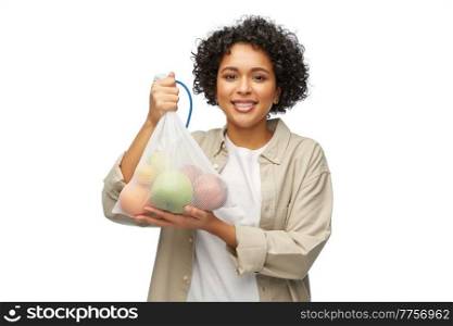 sustainability, eco living and people concept - portrait of happy smiling woman holding reusable string bag with fruits over white background. happy woman with fruits in reusable string bag