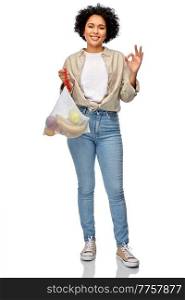 sustainability, eco living and people concept - portrait of happy smiling woman holding reusable string bag with fruits showing ok gesture over white background. happy woman with fruits in reusable string bag