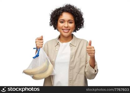 sustainability, eco living and people concept - portrait of happy smiling woman holding reusable string bag with bananas over white background. happy woman with bananas in reusable string bag