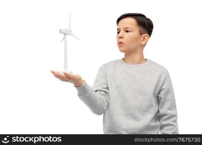 sustainable energy, power and people concept - boy with toy wind turbine over white background. boy with toy wind turbine