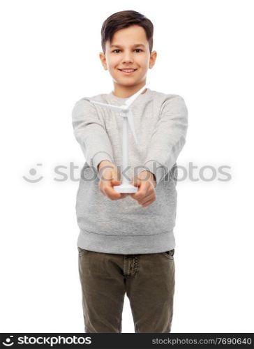 sustainable energy, power and people concept - happy smiling boy with toy wind turbine over white background. smiling boy with toy wind turbine