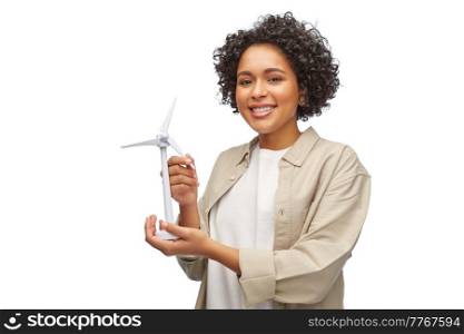 sustainable energy, power and people concept - happy smiling woman holding toy wind turbine over white background. happy woman holding toy wind turbine