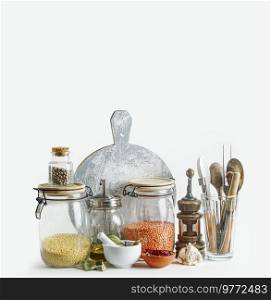 Sustainable kitchen setting with housekeeping jars and eco friendly kitchen utensils at white background. Front view. Modern still life