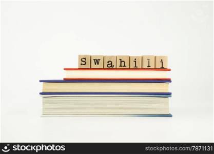 swahili word on wood stamps stack on books, foreign language and translation concept