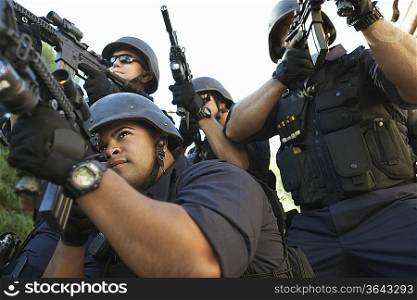 Swat officer aiming guns