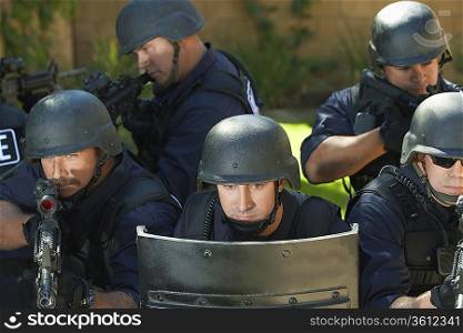 Swat officers behind shield