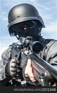 SWAT police sniper in black uniform in action. SWAT police sniper