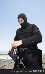 SWAT Team Officer Loading Pistol