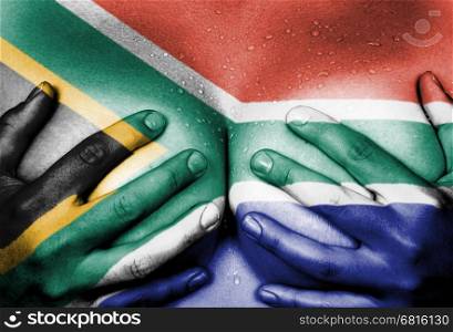 Sweaty upper part of female body, hands covering breasts, flag of South Africa