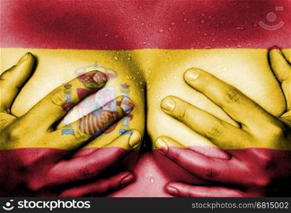Sweaty upper part of female body, hands covering breasts, flag of Spain