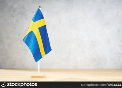 Sweden table flag on white textured wall. Copy space for text, designs or drawings