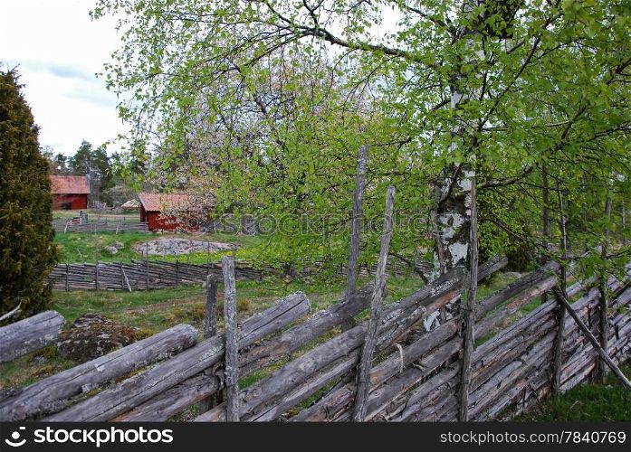 Swedish landscape with traditional fences and red houses. From the province Smaland in Sweden.