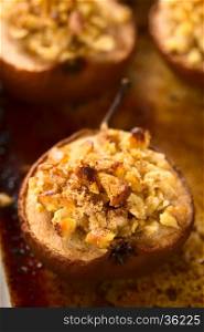 Sweet baked pear halves topped with a crisp crust of oatmeal, sugar and walnut, sprinkled with cinnamon, photographed with natural light (Selective Focus, Focus one third into the image)