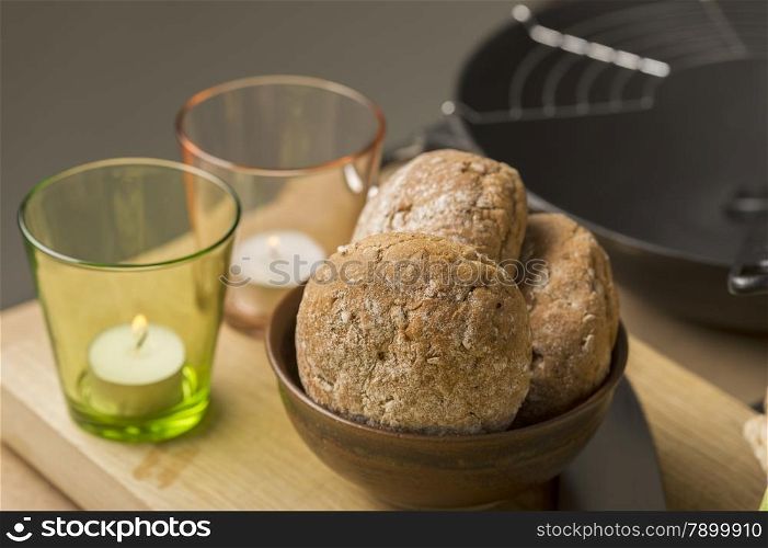 Sweet Bread on Bowl Beside Glasses. Close up Sweet Brown Bread on Bowl Beside Glasses with Candles on Top of Wooden Board.