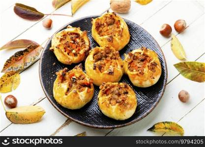 Sweet buns with nuts on the plate. Fall sweets, autumn dessert. Appetizing buns with nut filling.