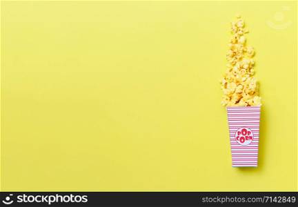 Sweet butter popcorn in box on yellow background , top view copy space