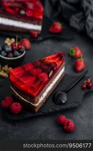 Sweet cake with fresh berries and jelly on old wooden board
