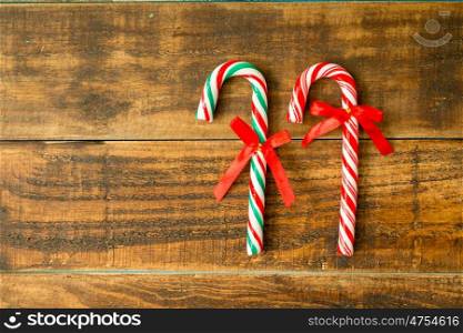 Sweet Candy Canes with red ribbon on a wooden background