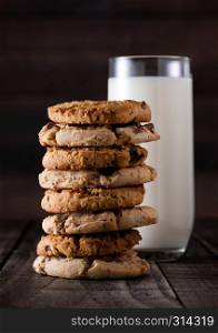 Sweet caramel and chocolate oatmeeal gluten free cookies on old wooden background with glass of milk