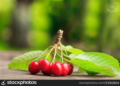 Sweet cherries on the wooden table outdoors