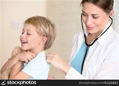 Sweet child visiting doctor, beautiful young specialist examines the health of a small patient, treatment in the good clinic, happy healthy childhood