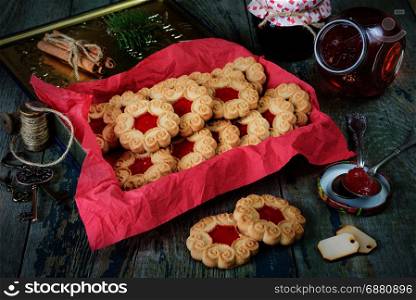Sweet Christmas cookies with jam and fir branche on the old wooden table