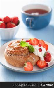 sweet cinnamon roll with cream and strawberry for breakfast
