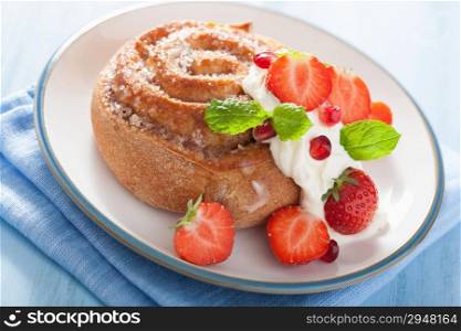 sweet cinnamon roll with cream and strawberry for breakfast