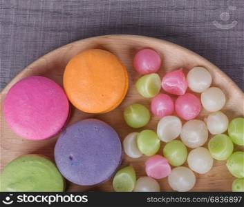 sweet colorful cake macaron and Aalaw or Alua candy in plate on wood table